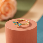 Teal enamel dragonfly ring on a textured antique gold-toned adjustable band