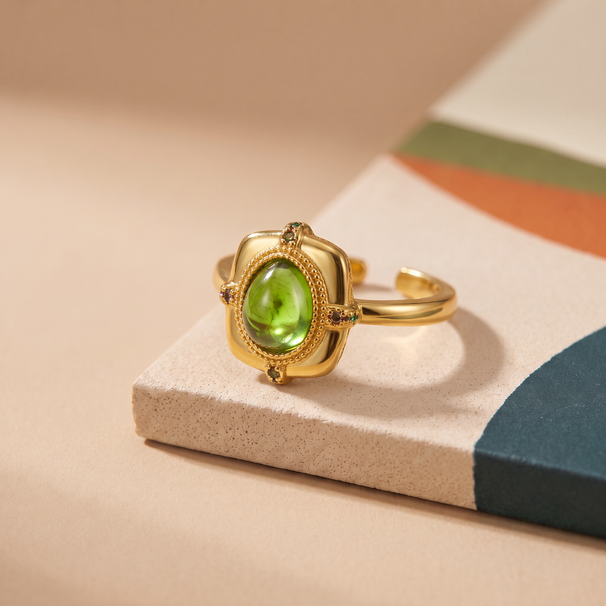 Peridot-green cabochon ring in a square vintage-style bezel, gold-toned adjustable